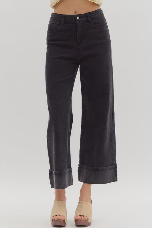 Black wide-leg jeans worn by a person on a plain background