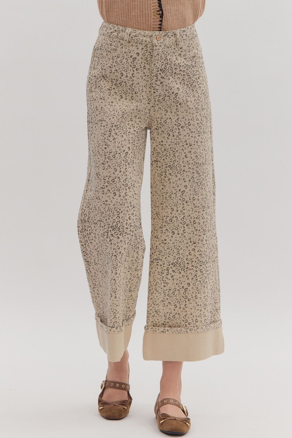 Leopard-patterned pants worn by a person on a plain background
