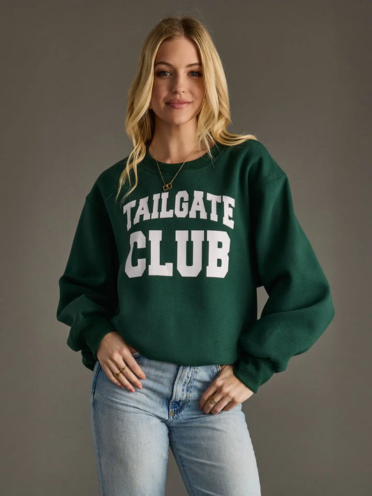 Person wearing a green 'Tailgate Club' sweatshirt against a gray background