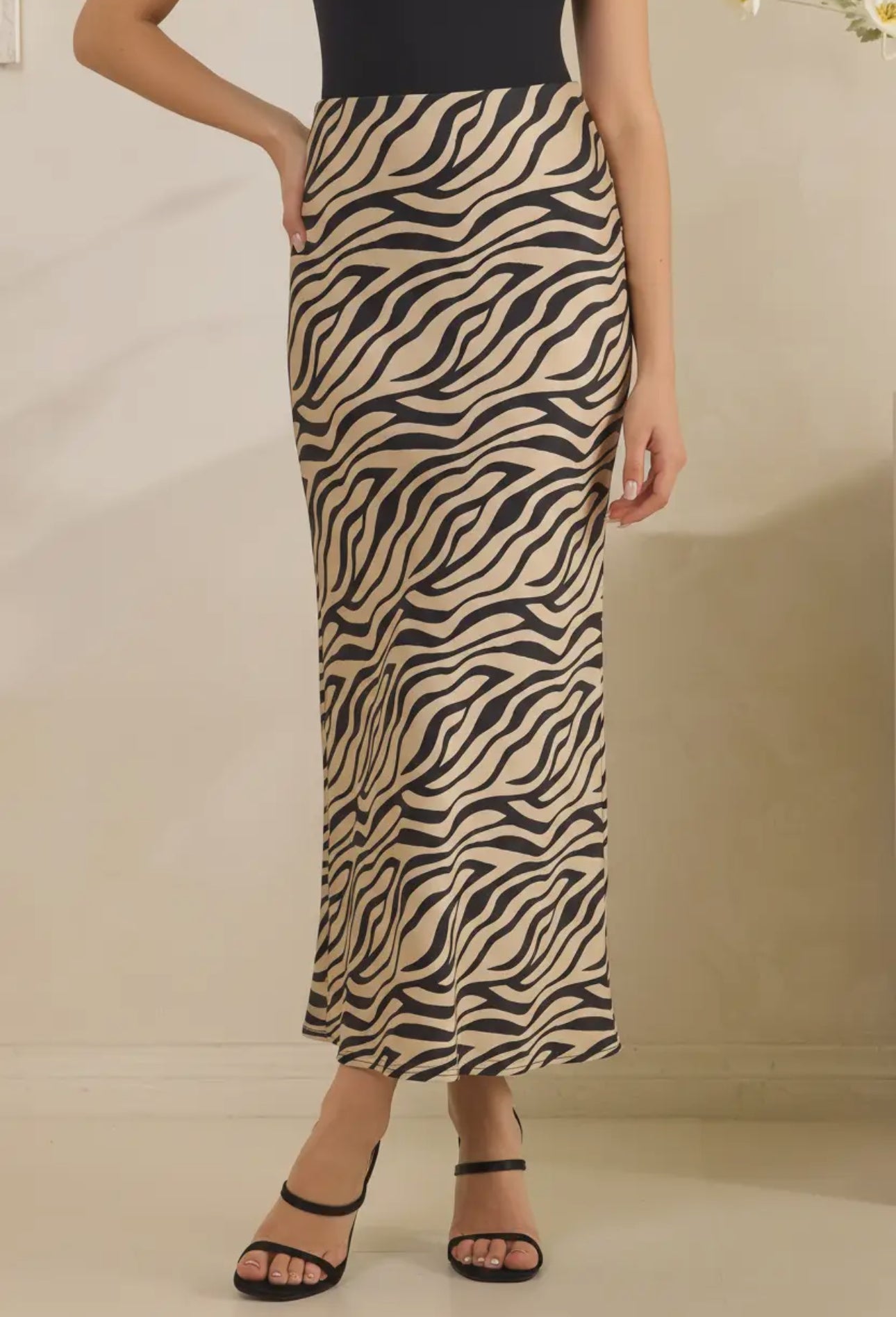 Person wearing a zebra print skirt on a plain background